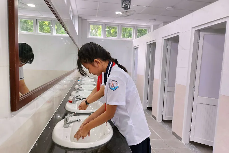 Học sinh Trường THCS Ngô Quyền (quận Tân Bình) sử dụng nhà vệ sinh mới, sạch sẽ. Ảnh: NGUYỄN QUYÊN