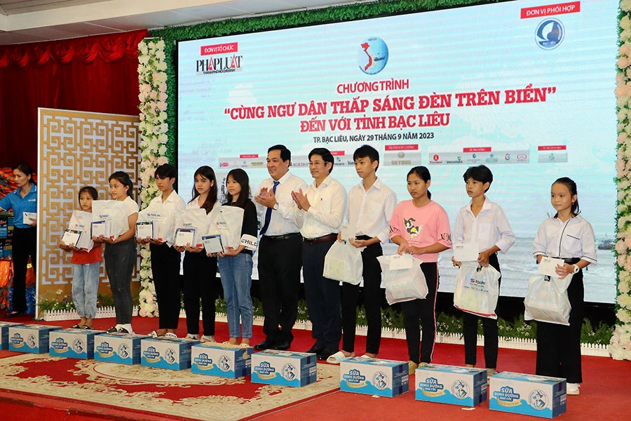 Trưởng ban Tuyên giáo Tỉnh ủy Bạc Liêu Tạ Trung Dũng cùng Phó Tổng Biên tập báo Pháp Luật TP.HCM Nguyễn Thái Bình trao tặng quà và học bổng cho các em học sinh. Ảnh: CHÂU ANH ngư dân bạc liêu