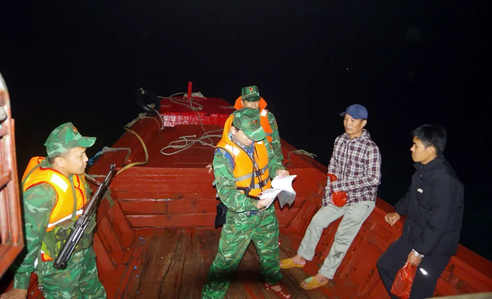 Lực lượng chức năng kiểm tra sổ nhật ký hành trình tàu ra khơi đánh bắt hải sải trên vùng biển Hà Tĩnh. Ảnh: T.MẠNH P45_Chinh_h2.jpg