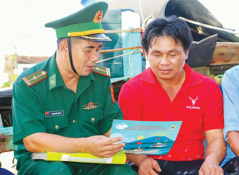 Lực lượng biên phòng Trà Vinh xuống tận tàu cá để tuyên truyền cho ngư dân tuân thủ pháp luật khi đánh bắt hải sản. Ảnh: CHÂU ANH P3_Cot-phai.jpg