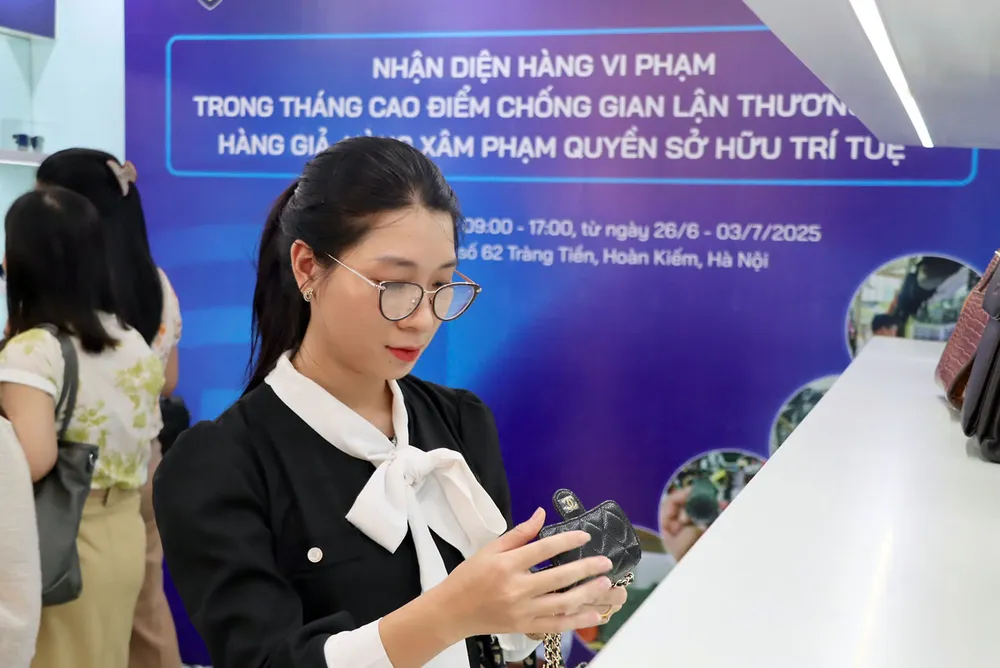 Người dân tìm hiểu thông tin về sản phẩm vi phạm tại phòng trưng bày của Cục Quản lý và Phát triển thị trường trong nước. Ảnh: AH p23-toadamhanggia-hinhphu2.jpg