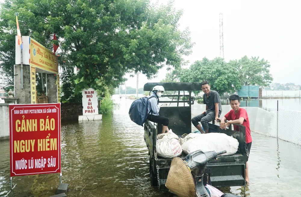 Đường vào xóm Bến Vôi (xã Cấn Hữu, huyện Quốc Oai, Hà Nội) được treo biển cảnh báo nguy hiểm. (Ảnh: Phi Hùng) song-chung-voi-lu-6-ngay5.jpg