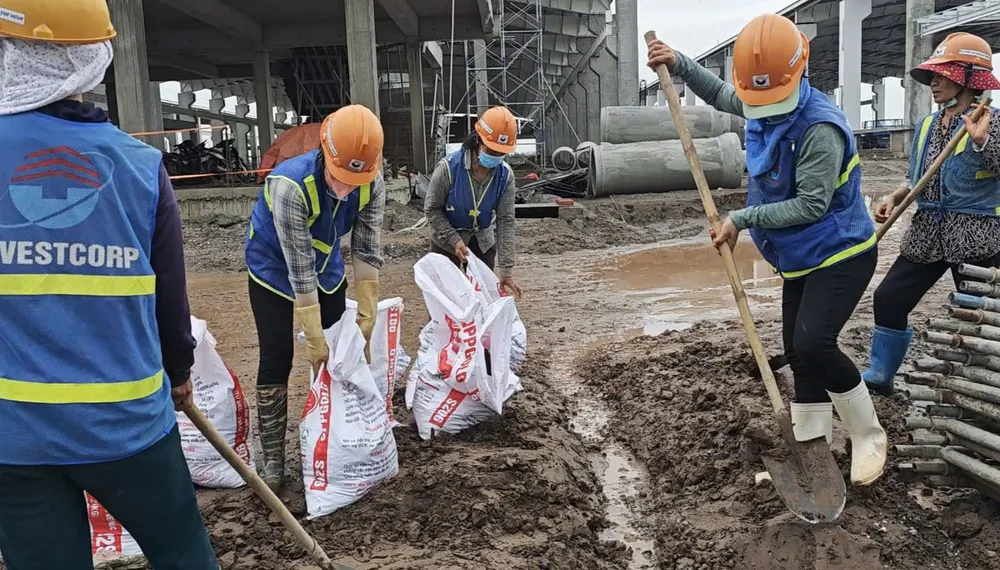 Công nhân thi công tại công trường đang thi công nhà máy dệt may JeHong Textile (thuộc khu công nghiệp Rạng Đông, Nghĩa Hưng, Nam Định) chuẩn bị bao tải cát để phòng chống bão số 3. (Ảnh: Trọng Phú)