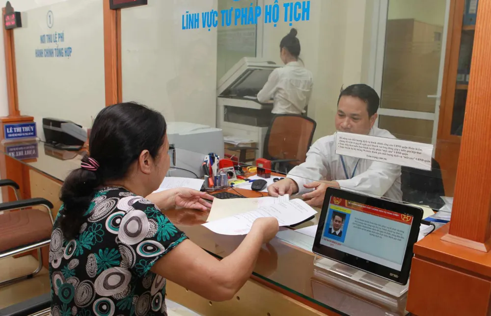 Người dân đang làm thủ tục hành chính. thu-tuc-hanh-chinh-ha-noi.jpg