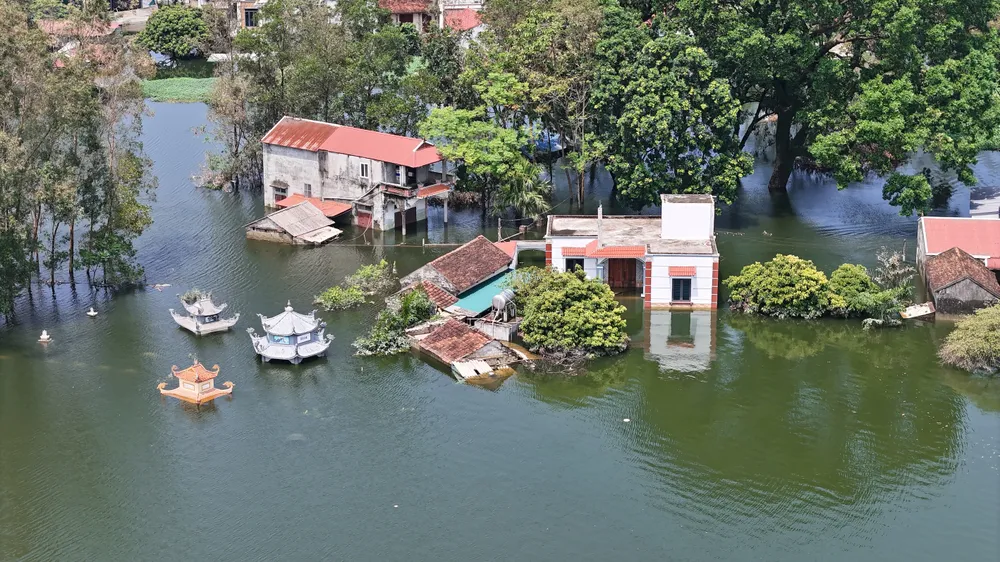 Mồ mả của người đã khuất, lẫn nhà của của người sống đều bị nước lũ nhấn chìm. (Ảnh: Trọng Phú) ron-lu-cua-Ha-Noi-2.JPG