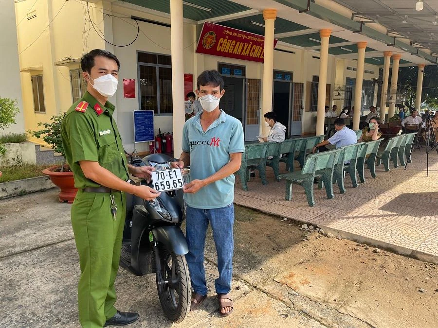 Một người dân vui mừng khi được cấp biển số xe máy ở công an xã. Ảnh: NHẬT NHẬT