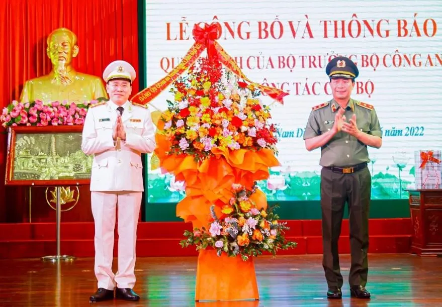 Trung tướng Lê Quốc Hùng, Thứ trưởng Bộ Công an tặng hoa chúc mừng Đại tá Phạm Văn Long (trái). Ảnh: CACC
