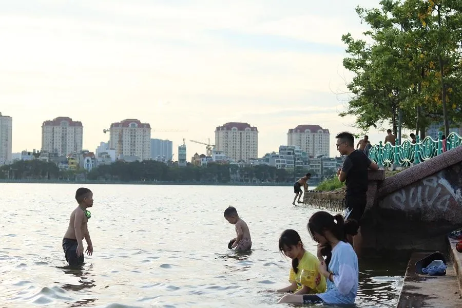 Cuối buổi chiều, nhiều người bao gồm cả người lớn và trẻ nhỏ tập trung tại hồ Tây để tắm mát. Đây là địa điểm giải nhiệt yêu thích của những đứa trẻ.