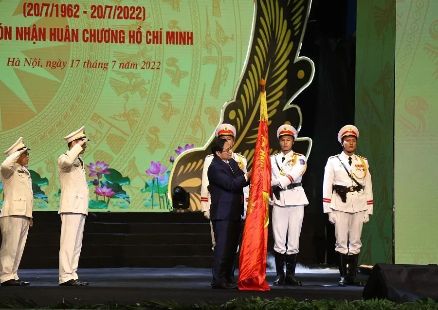 Thủ tướng Phạm Minh Chính gắn Huân chương Hồ Chí Minh lên Cờ truyền thống của lực lượng Cảnh sát nhân dân. Ảnh: UYÊN TRANG