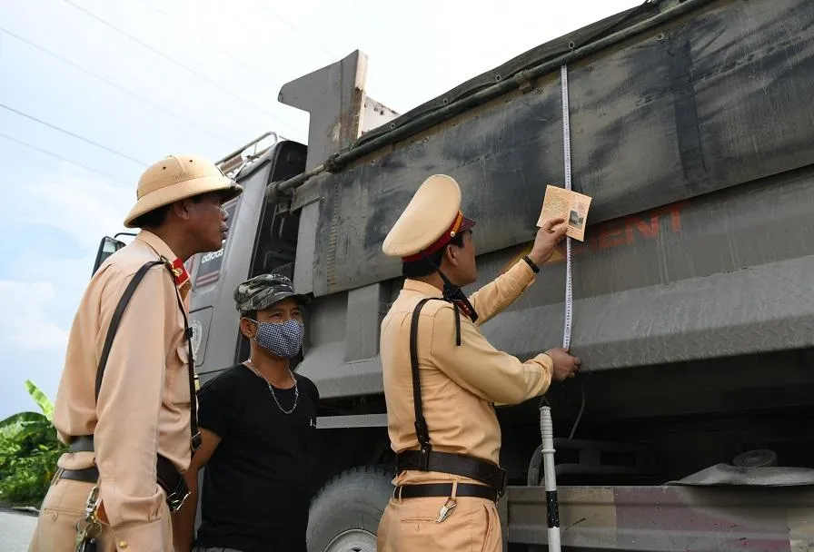 CSGT kiểm tra kích thước thùng một xe tải. Ảnh: UYÊN TRANG