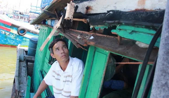 Ông Tuấn với chiếc tàu bị đâm rách toạc - Ảnh: Trần Mai Tàu Trung Quốc tông tàu cá Việt Nam ở Hoàng Sa