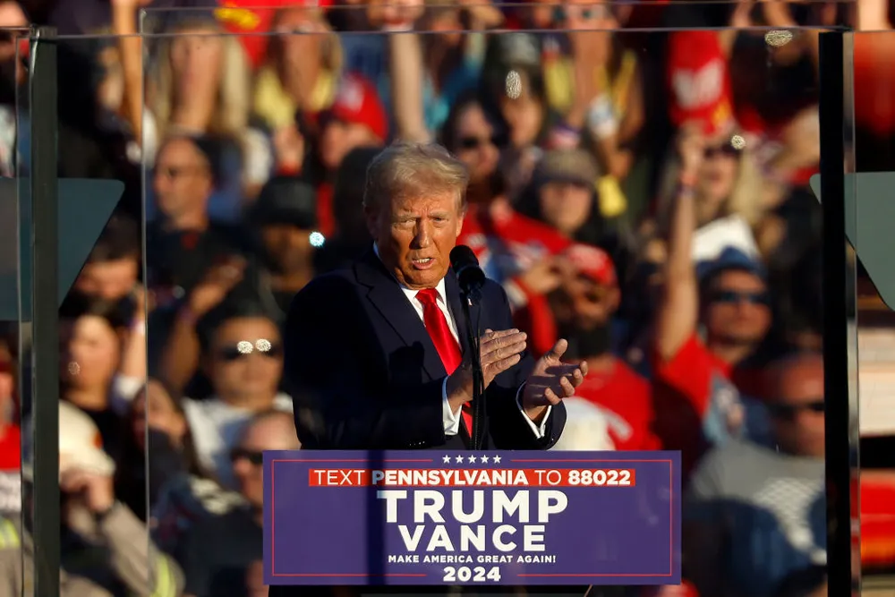 Ông Donald Trump phát biểu sau lớp kính dày bảo vệ tại sự kiện tranh cử ở TP Butler, bang Pennsylvania hôm 5-10. Ảnh: GETTY IMAGES Donald Trump trở lại nơi xảy ra vụ ám sát hụt lần 1.jpg