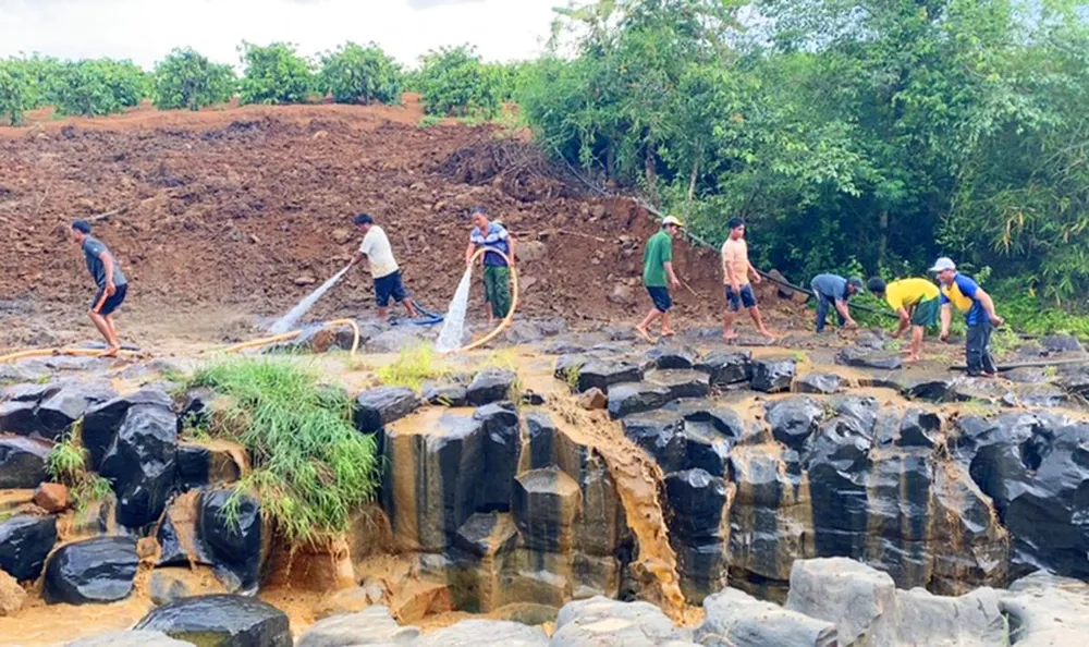 Chính quyền thị trấn Ia Ly và người dân di dời phần đất xâm lấn, làm sạch như ban đầu. Ảnh: CD.