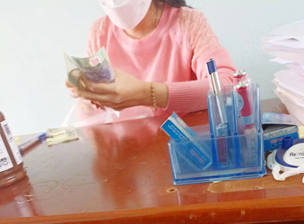 Nhân viên trung tâm nhận tiền "bao đậu" lý thuyết. Ảnh: Học viên cung cấp.