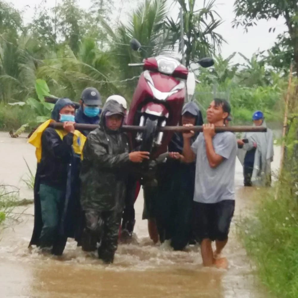 Người dân giúp nhau đưa xe máy qua vùng ngập.