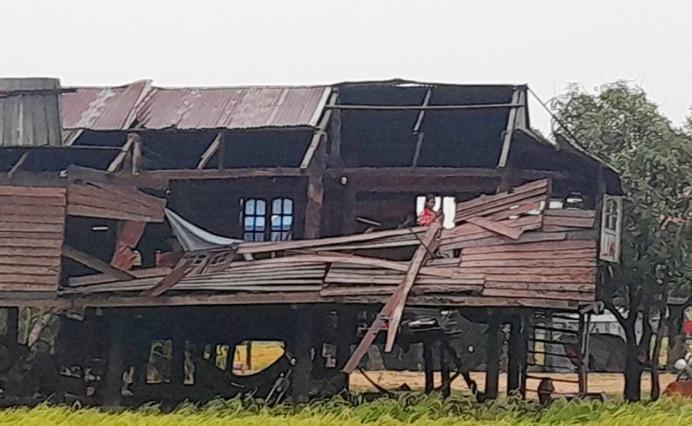 Một nhà sàn bị tốc gần hết phần mái.