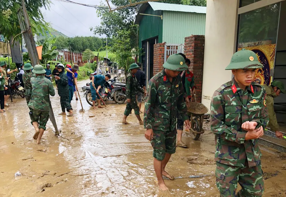 Lực lượng chức năng giúp dân khắc phục mưa lũ.