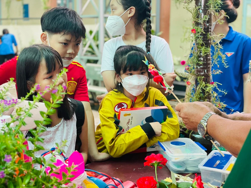Nhiều em nhỏ thích thú với nặn tò he tại gian hàng trưng bày sản phẩm tái chế của Hội Cựu chiến binh xã. Ảnh: VIỆT HOA