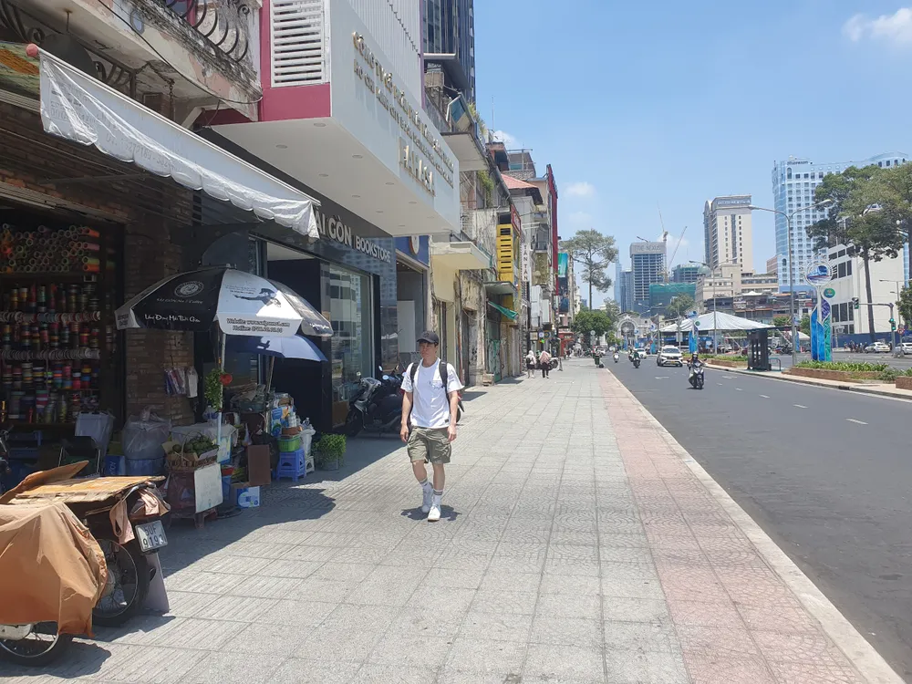 Du khách &quot;đội nắng&quot; trên đường Lê Lợi trưa ngày 26-3. Ảnh KC