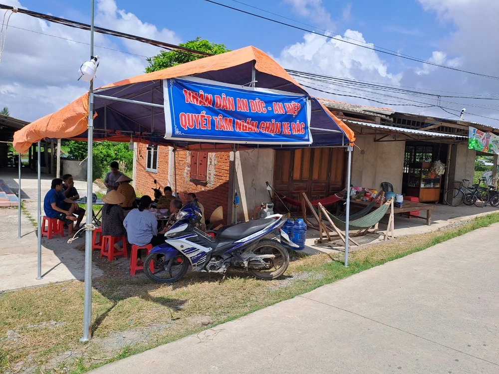 Người dân vẫn túc trực ngày đêm canh chặn xe rác vào bãi rác An Hiệp. Ảnh ĐÔNG HÀ