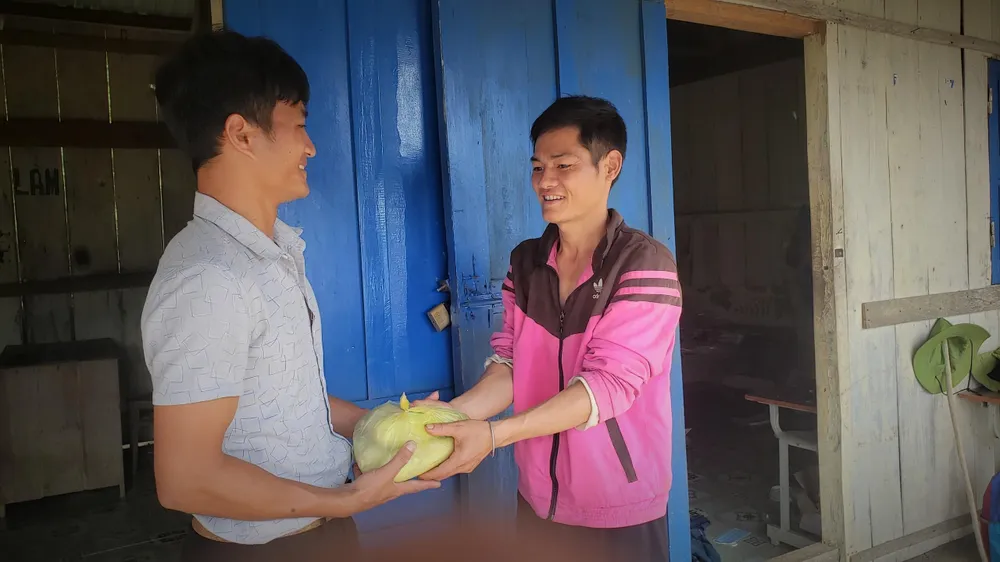 Phụ huynh học sinh tặng thầy Bửu trái bắp trước khi thầy về nghỉ hè.