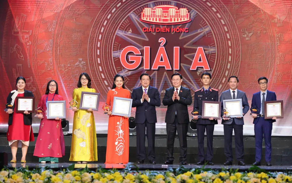 Chủ tịch Quốc hội Vương Đình Huệ và Trưởng ban Nội chính Trung ương Phan Đình Trạc trao giải cho 7 đại diện nhóm tác giả đoạt giải A. Ảnh: QUANG PHÚC giai-a-3917.jpeg