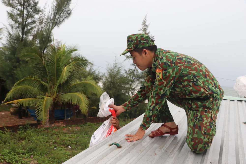 Lực lượng bộ đội đến từng nhà hỗ trợ người dân chống bão.