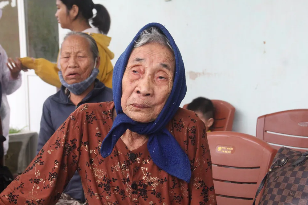 Một cụ già đến từ rất sớm, chờ xe đến đón. Ảnh: THANH NHẬT Một cụ già đến từ rất sớm, chờ xe đến đón. Ảnh: THANH NHẬT