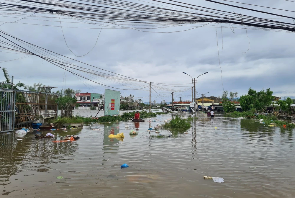 Chợ Chiên Đàn bị ngập sâu, người dân tranh thủ vào dọn dẹp. Ảnh: THANH NHẬT