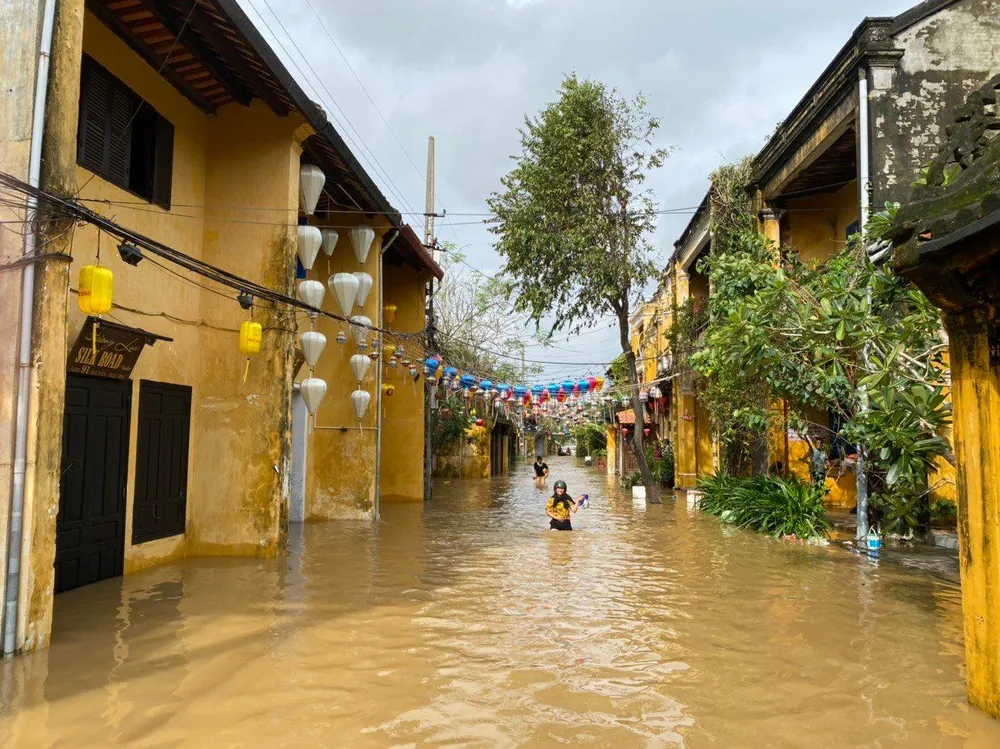 Đường Nguyễn Thái Học ngập khoảng 1 m, người dân tranh thủ lội nước ra ngoài.