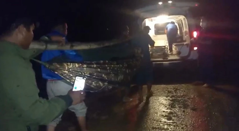 Người dân khiêng bệnh nhân băng qua nhiều điểm sạt lở để xe cấp cứu đưa đến bệnh viện. Ảnh chụp từ clip