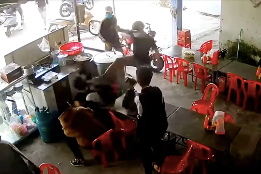 Nhóm người bịt khẩu trang, xông vào quán nước đánh hai nam sinh. Ảnh chụp từ clip.