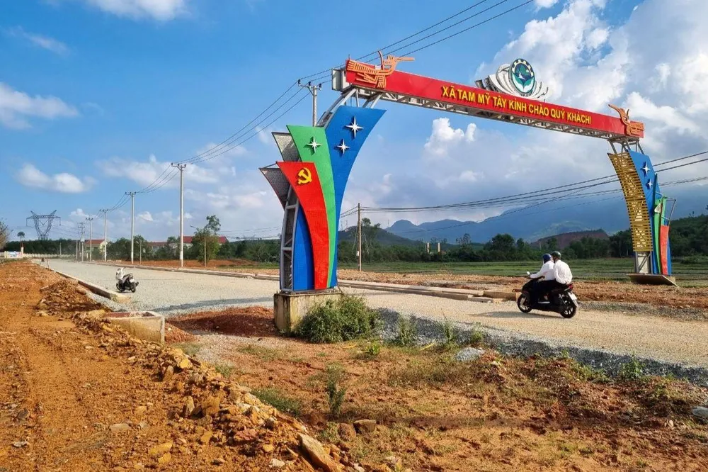 Một trụ cổng chào xã Tam Mỹ Tây nằm giữa đường mới. Ảnh: TN