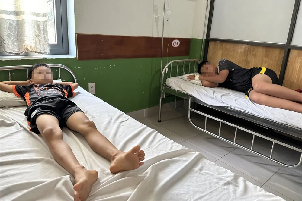 Bốn em nhỏ đang điều trị tại bệnh viện, một em đang truyền nước. Ảnh: TN nguoi-phu-nu-bi-to-danh-4-em-nho-nhap-vien-4.jpeg