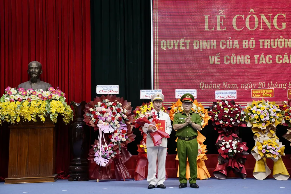 Trung tướng Nguyễn Văn Long trao quyết định, tặng hoa chúc mừng Đại tá Nguyễn Hữu Hợp. Ảnh: TN Bộ Công an công bố quyết định bổ nhiệm Giám đốc Công an tỉnh Quảng Nam