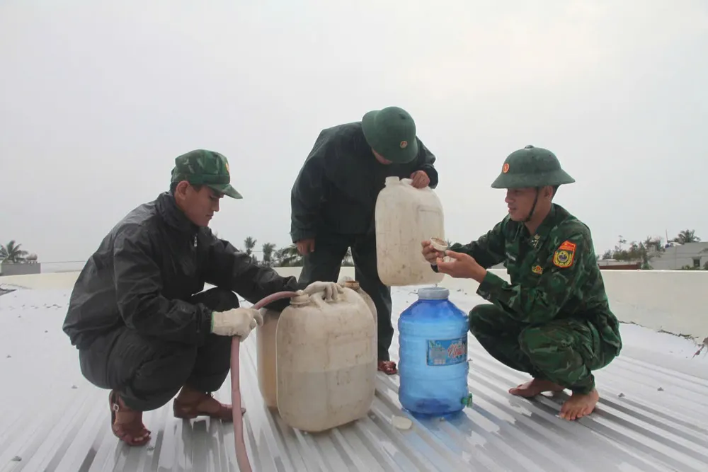 Chiến sĩ Đồn Biên phòng Tam Thanh (thuộc Bộ đội Biên phòng Quảng Nam) giúp dân chằng nhà chống bão Trà Mi. Ảnh: HA bo-doi-giup-dan-chang-nha-chong-bao-Tra-mi-1.jpeg