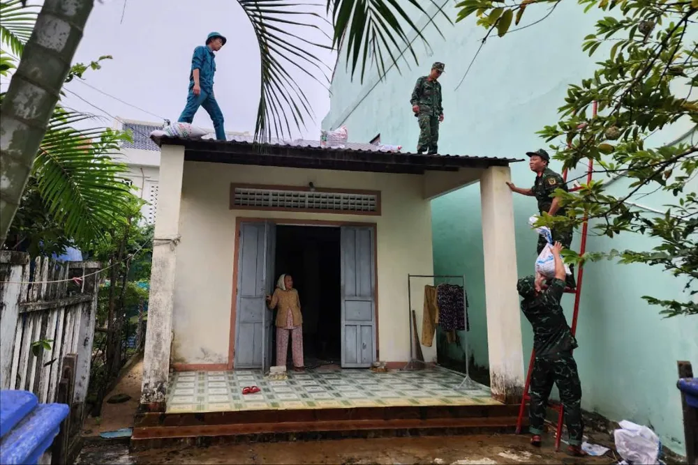 Tại TP Hội An, từ sáng sớm lực lượng dân quân, bộ đội đến giúp dân chằng nhà chống bão Trà Mi. Ảnh: AH bo-doi-giup-dan-chang-nha-chong-bao-Tra-mi-3.jpeg