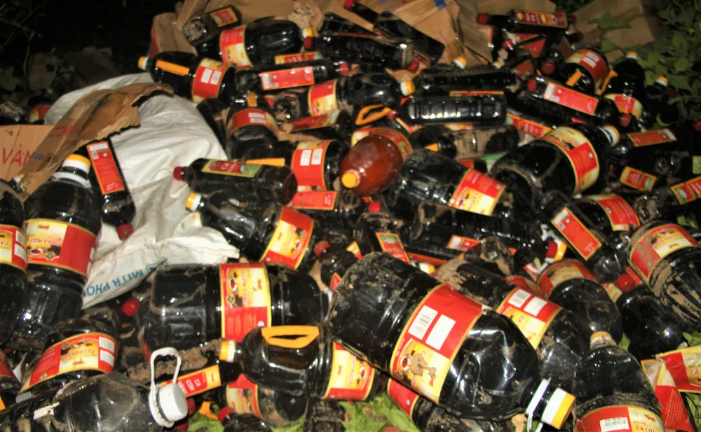 Cả ngàn chai nước mắm vứt bỏ bên đường. Ảnh: TN