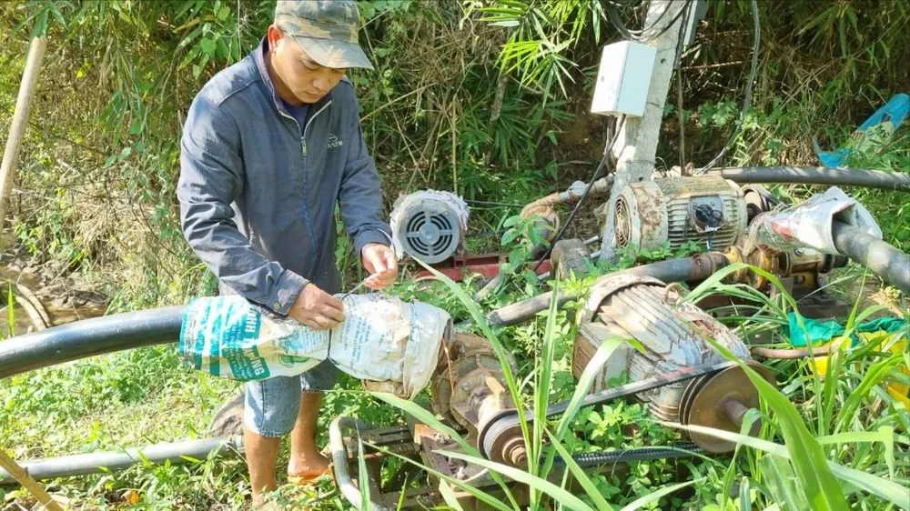 Năm chiếc máy bơm im lìm bên suối Đắk Mhăng vì không có nước. Ảnh: T.T NẮNG HẠN 5.jpg