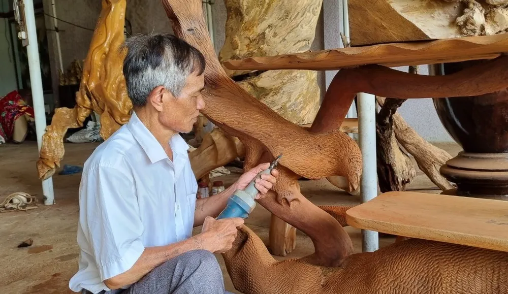 Ông Chương đang tạo họa tiết cho một sản phẩm đồ gỗ. Ảnh: TIẾN THOẠI nghiện ma túy 2.jpg