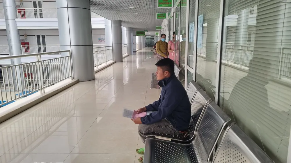 Anh Trang đến bệnh viện hoàn tất viện phí cho con gái. Ảnh: TIẾN THOẠI anh Trang chờ rút hồ sơ.jpg