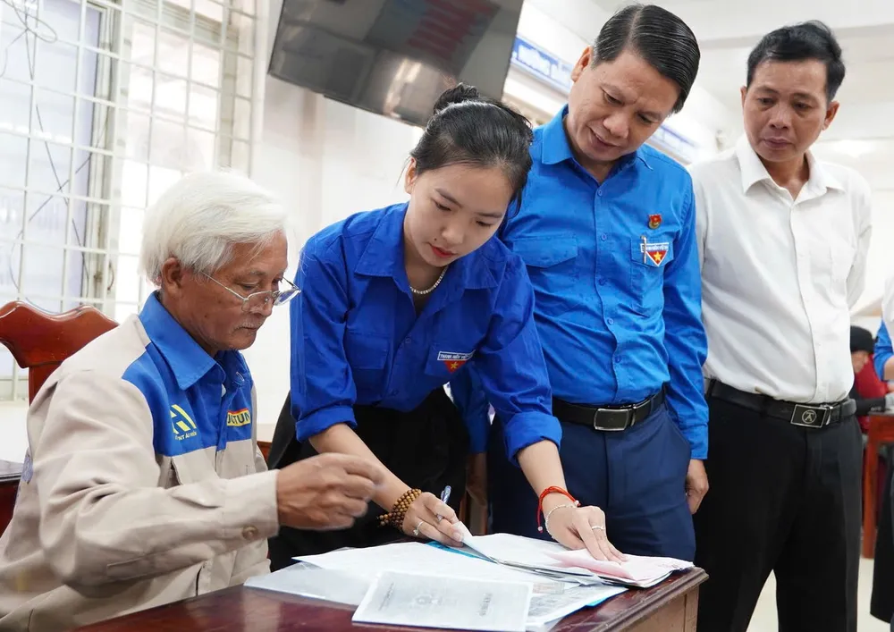 Thanh niên tình nguyện hỗ trợ người dân làm hồ sơ. Ảnh: D.K