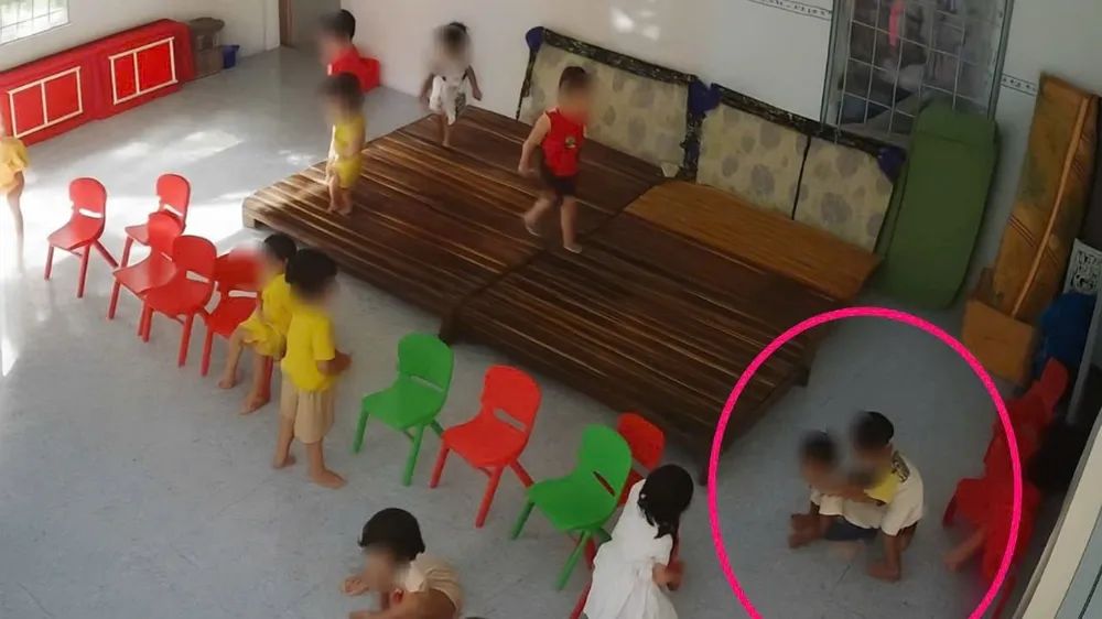 Bé trai (phía dưới, khung tròn) bị bàn xô, cào cấu. Ảnh chụp màn hình mạng xã hội.jpg