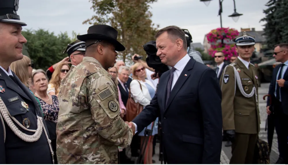 Bộ trưởng Quốc phòng Ba Lan – ông Mariusz Blaszczak (phải) đến thăm thành phố Augustow ngày 23-7. Ảnh: FAKT