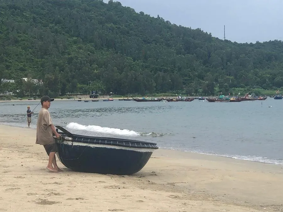 Ngư dân kéo thúng lên bờ trước khi bão đổ bộ-Ảnh: NGÔ QUANG