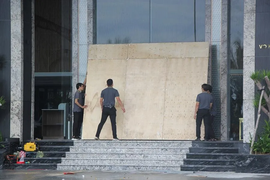Nhiều khách sạn ven biển gia cố cửa ra vào bằng cách đóng ván gỗ, dùng vật dụng chèn trước cửa để tạo độ kiên cố trước gió bão. Ảnh: NGÔ QUANG