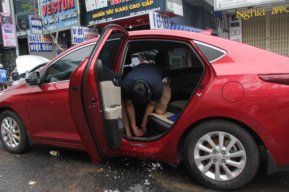 Chủ xe phải dùng tay để tạt bớt nước trong xe ra-Ảnh: NGÔ QUANG