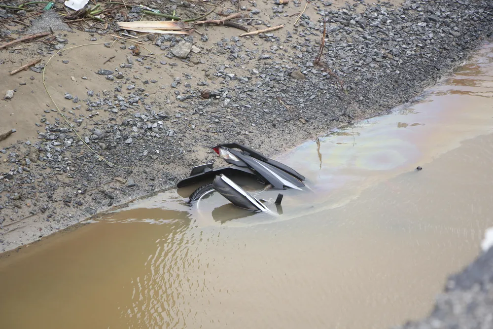 Chiếc xe máy nằm lọt thỏm dưới điểm sụt lún-Ảnh: NGÔ QUANG