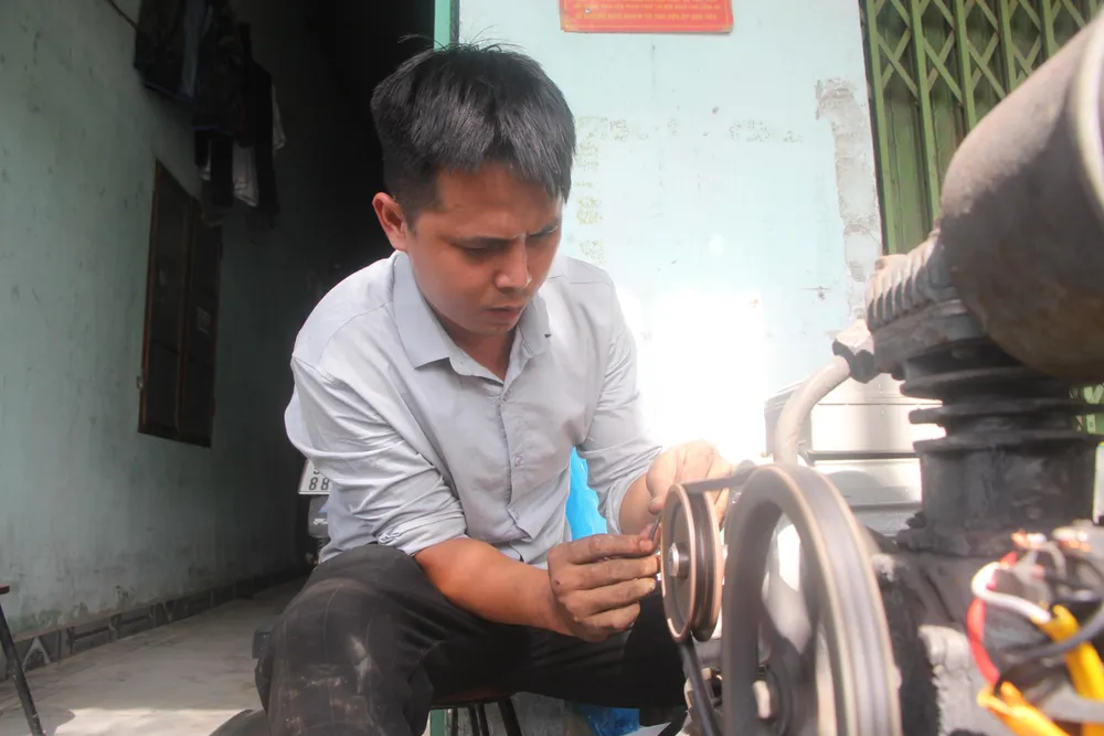 Anh Cảnh đang mài lại roan xe cho người dân-Ảnh: NGÔ QUANG Anh Cảnh đang mài lại roan xe cho người dân-Ảnh: NGÔ QUANG