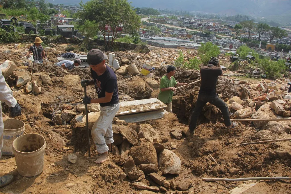 Người dân đang đào các phần mộ bị chôn vùi. Ảnh: NGÔ QUANG Người dân đang đào các phần mộ bị chôn vùi. Ảnh: NGÔ QUANG